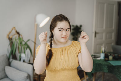 Woman with down syndrome gesturing at home