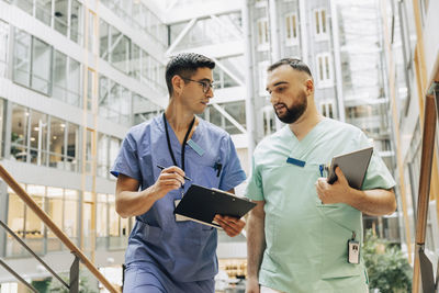 Mature male staff discussing with colleague at hospital