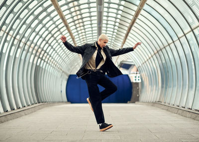 Full length of woman dancing in tunnel