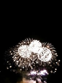 Low angle view of fireworks against sky at night