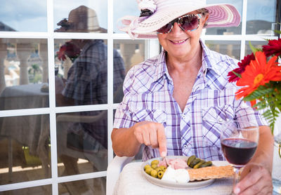 Portrait of woman holding ice cream in glass on table