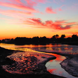 Scenic view of lake against orange sky