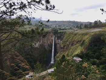 Scenic view of waterfall against sky