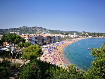 High angle view of buildings by sea against clear sky