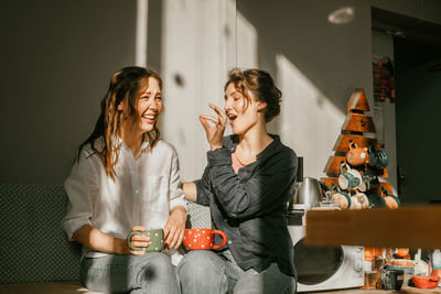 Cozy morning, girls friends talking over cup of coffee