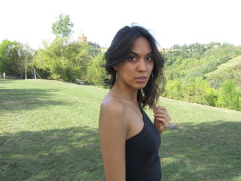Portrait of young woman standing on field