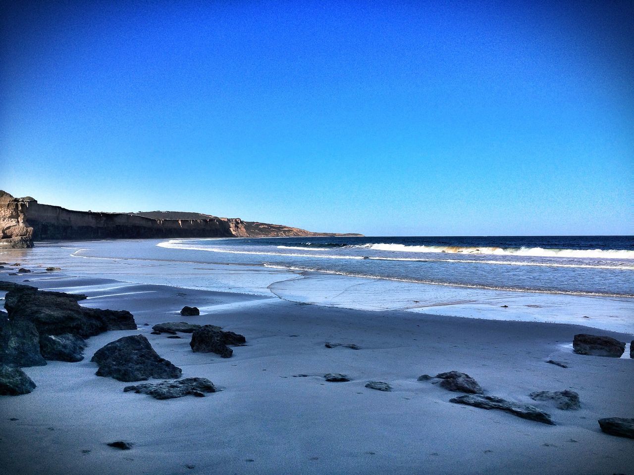 clear sky, copy space, beach, water, blue, sea, tranquil scene, tranquility, scenics, shore, beauty in nature, sand, nature, horizon over water, idyllic, coastline, rock - object, outdoors, day, non-urban scene