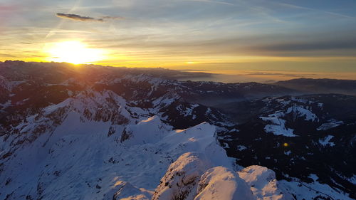 Scenic view of snowcapped mountains against sky during sunset