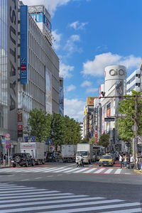 View of city street against cloudy sky