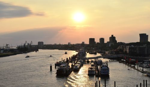 Panoramic view of sea and buildings against sky during sunset