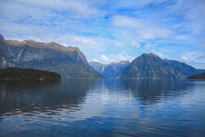 Scenic view of lake by mountains against sky