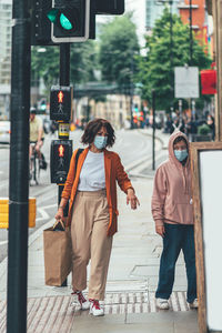 Women walking on sidewalk in city