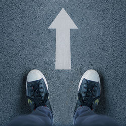 Low section of man standing on road