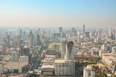 Aerial view of buildings in city against clear sky