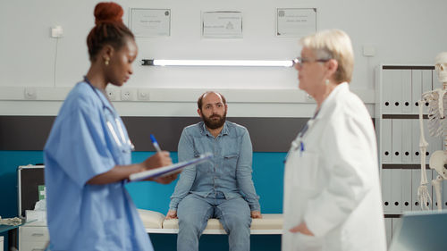 Side view of doctor giving medicine to patient at clinic