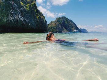 Woman swimming in sea against sky