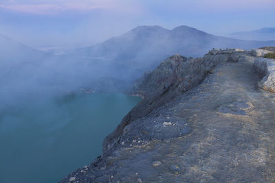 Smoke emitting from volcanic mountain against sky