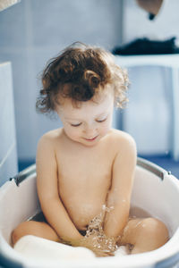 Midsection of shirtless boy in bathroom at home