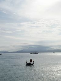 People on boat in sea against sky
