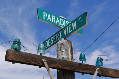 Low angle view of road sign against blue sky