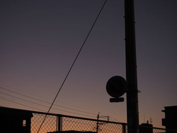 Low angle view of silhouette cables against clear sky