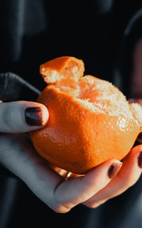Close-up of hand holding orange slice
