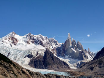 Scenic view of snowcapped mountains against clear blue sky