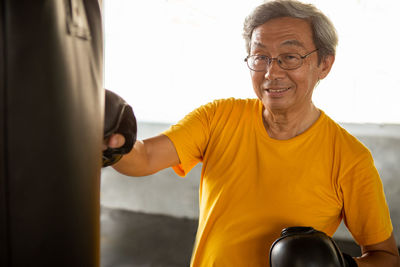 Portrait of smiling man standing against wall