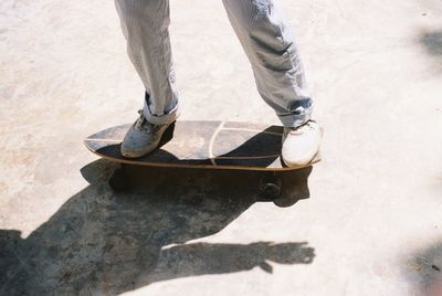 Low section of man standing on skateboard