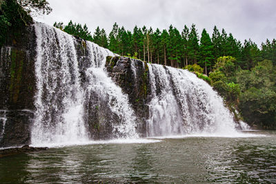 Scenic view of waterfall against sky