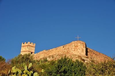 Low angle view of old castle against clear blue sky