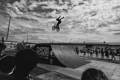 People jumping against sky