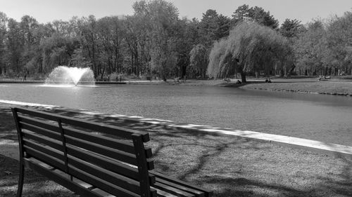 Bench by lake in park