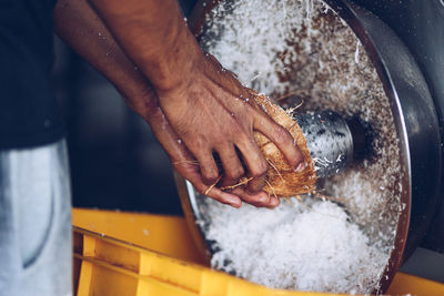 Close-up of human hand shredding coconut