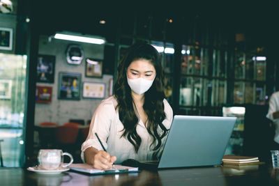Portrait of young woman using smart phone in cafe