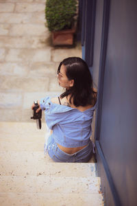 High angle view of woman sitting on staircase