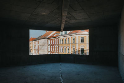 View out of a huge window at a construction site towards a residential building