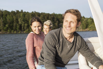 Happy friends travelling on yacht at river