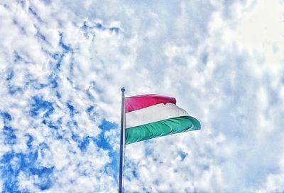 Low angle view of american flag against cloudy sky