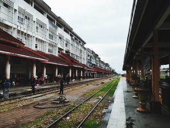 Railroad tracks in city against sky