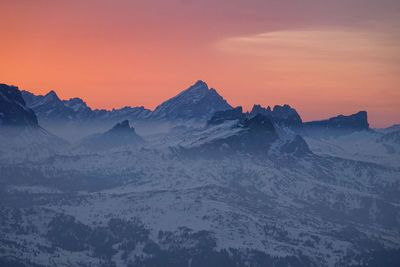 Scenic view of snowcapped mountains against sky during sunset