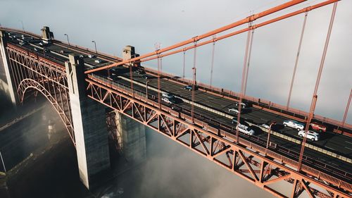 Low angle view of suspension bridge against sky