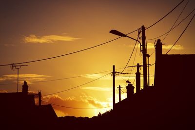 Low angle view of silhouette building against orange sky