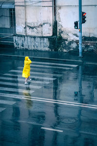 Person walking on wet road during rainy season