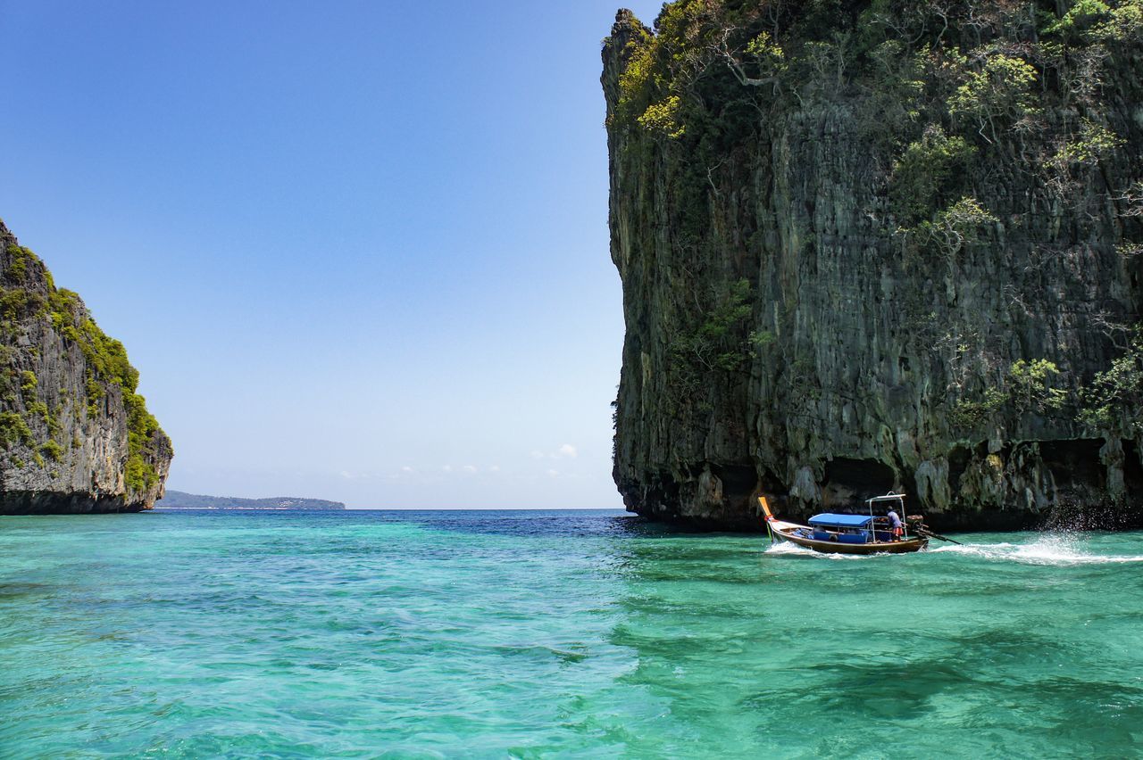 water, transportation, mode of transportation, sea, nautical vessel, beauty in nature, waterfront, nature, scenics - nature, rock formation, day, sky, rock, rock - object, travel, solid, tranquility, cliff, tranquil scene, outdoors, turquoise colored