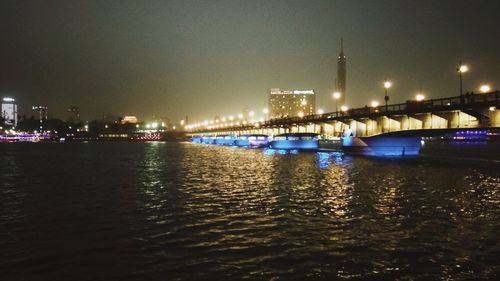 View of bridge over river at night