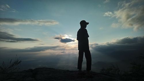 Silhouette man standing against sky during sunset