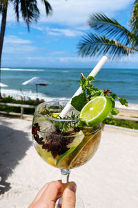 Midsection of person holding ice cream on beach