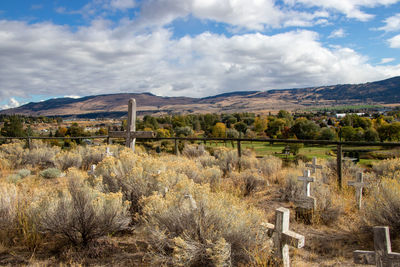 Rustic cemetery and scenic view of field against sky in merritt, british columbia 