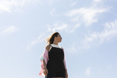 Low angle view of woman standing against sky